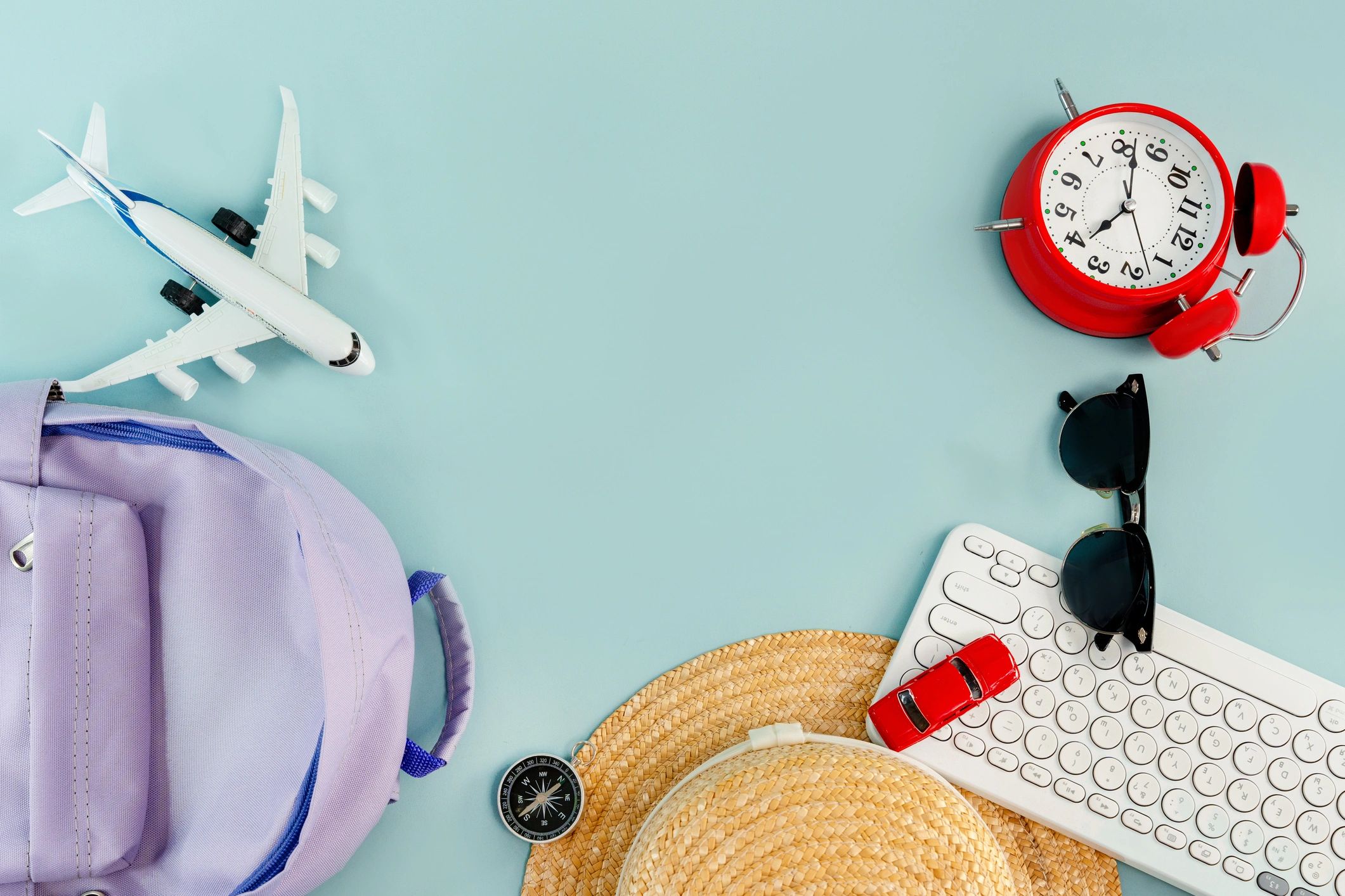 Travel essentials flat lay with airplane and keyboard