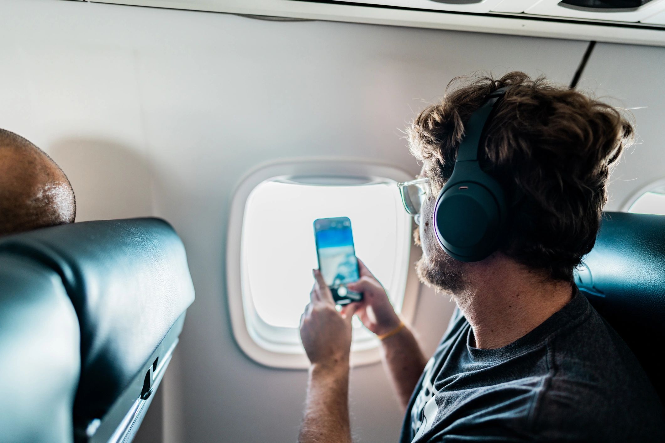 Traveler using a phone on an airplane