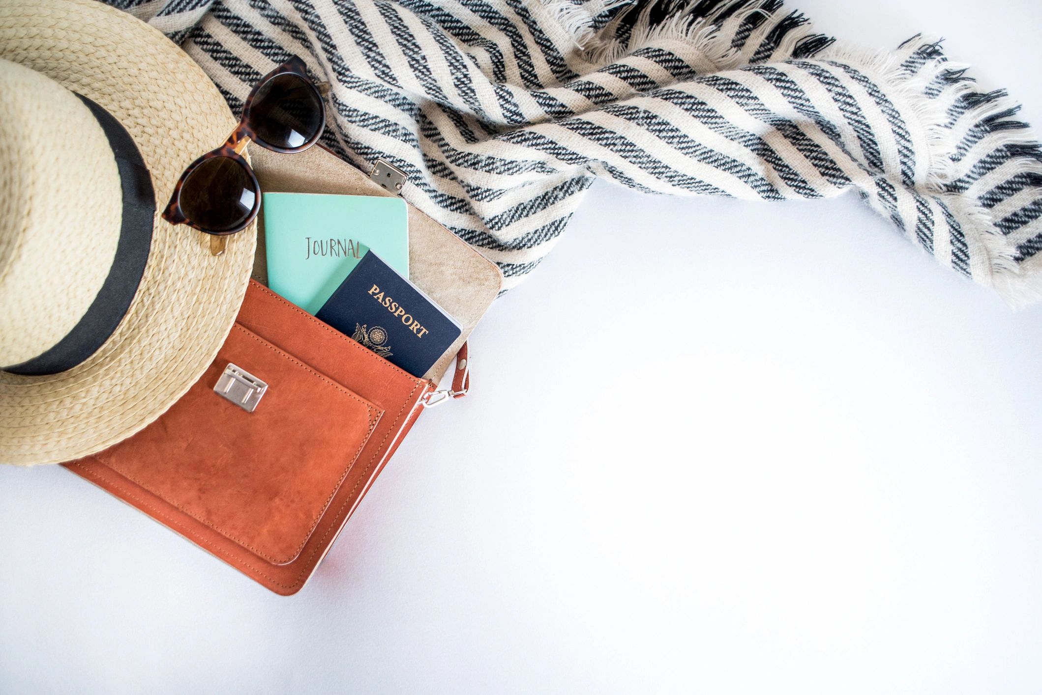 Passport and boarding pass flat lay with travel essentials